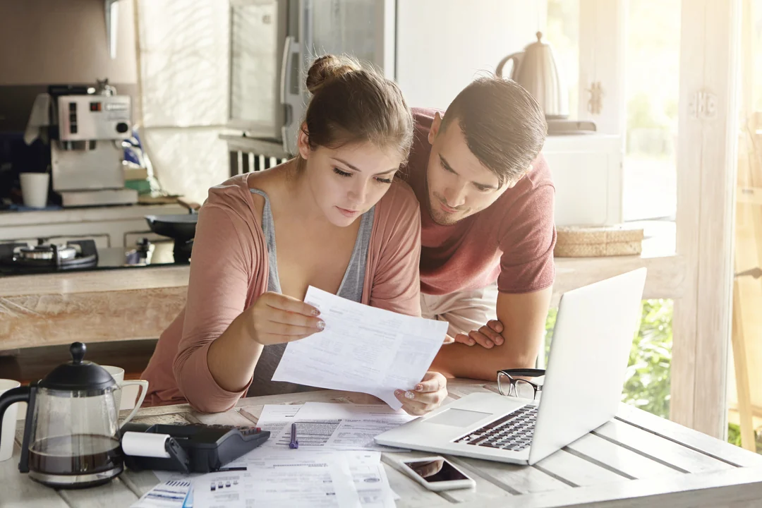 Casal calculando o ITBI e os custos de transferência do imóvel