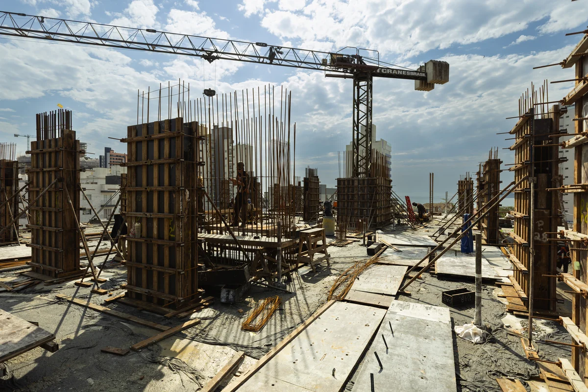 Vista ampla do canteiro de obras da CILL com pilares, formas e grua em Balneário Piçarras
